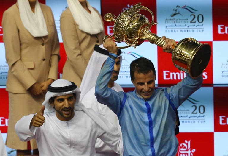 Jockey William Buick (R) and Sheikh Hamdan Bin Mohamed Bin Rashid al-Maktoum, Crown Prince of Dubai, celebrate on the podium after Prince Bishop won the US$10 million Dubai World Race on March 28, 2015