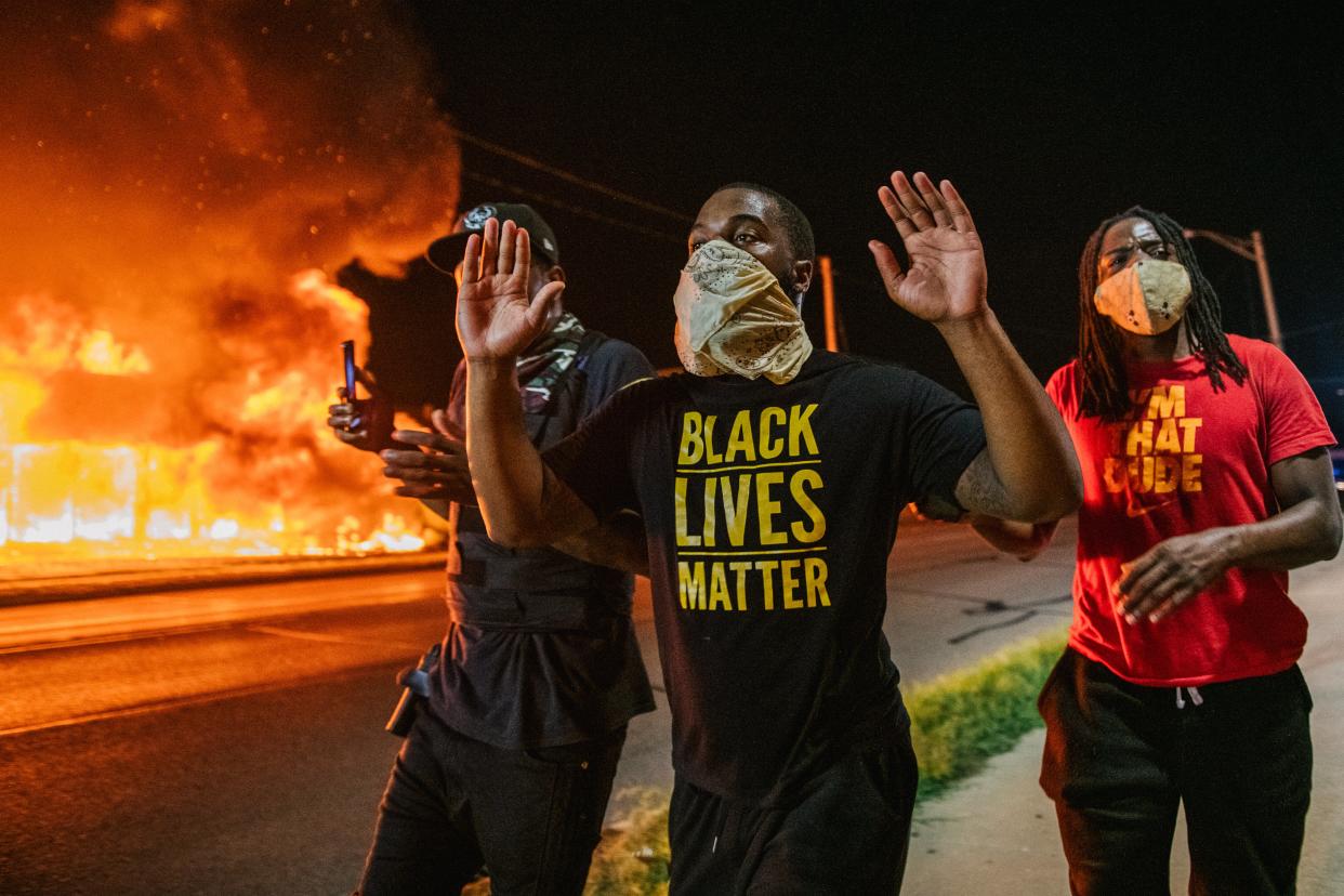 <p>Men walk towards law enforcement with their hands up on August 24, 2020 in Kenosha, Wisconsin. A second night of civil unrest occurred after the shooting of Jacob Blake, 29, on August 23.</p> (Photo by Brandon Bell/Getty Images)