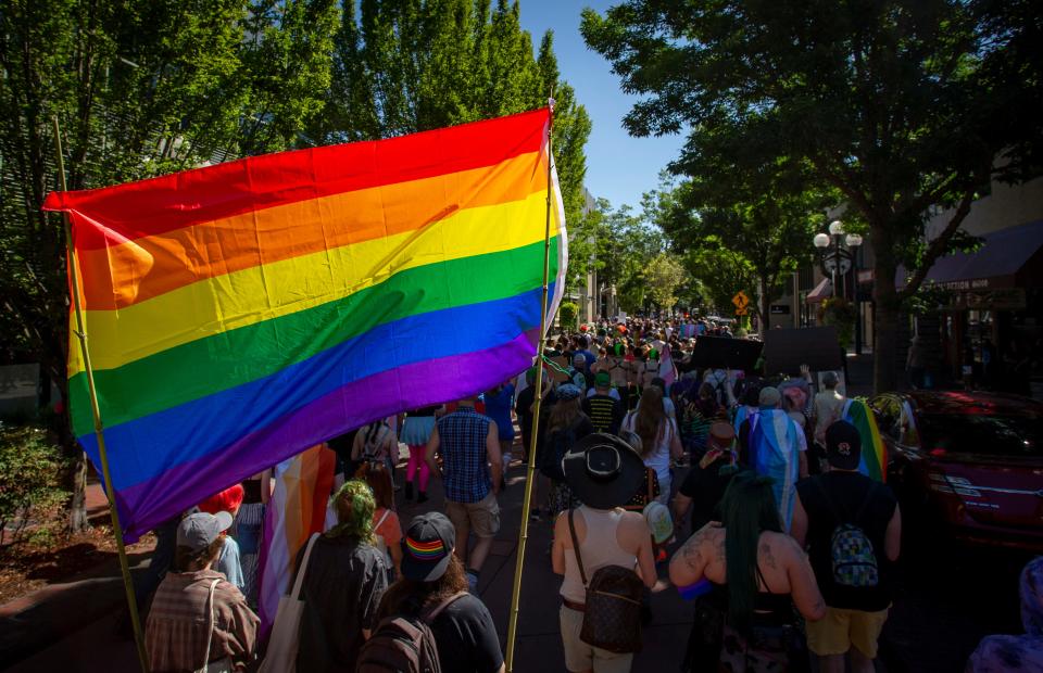 A large Pride flag hangs over marchers as they make their way down East Broadway during Eugene’s Pride in the Park at Alton Baker Park Saturday, Aug. 13, 2022.