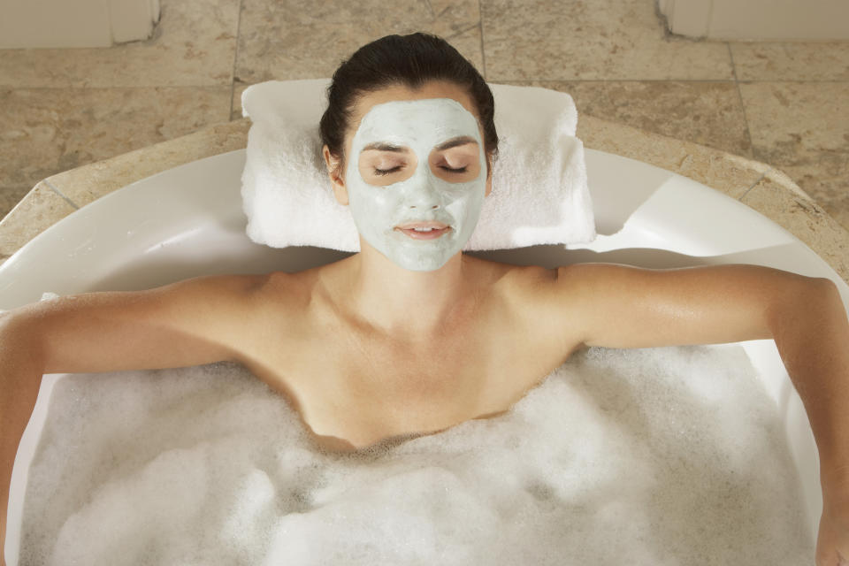 High angle view of a young woman in a bubble bath with her eyes closed