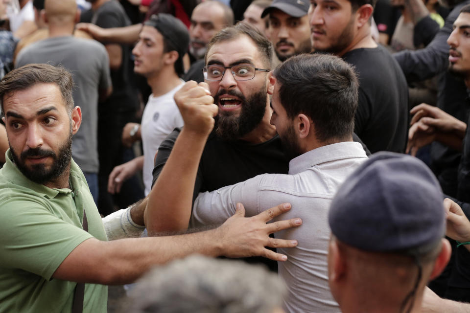 FILE - In this Oct. 25, 2019 file photo, anti-government protesters and Hezbollah supporters clash during a protest in Beirut, Lebanon. Lebanon’s protests have shown unusual overt anger at the country’s powerhouse, Hezbollah. (AP Photo/Hassan Ammar, File)