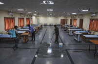 Indian workers disinfectant an isolation center for COVID-19 positive people in Hyderabad, India, Monday, May 3, 2021. (AP Photo/Mahesh Kumar A.)