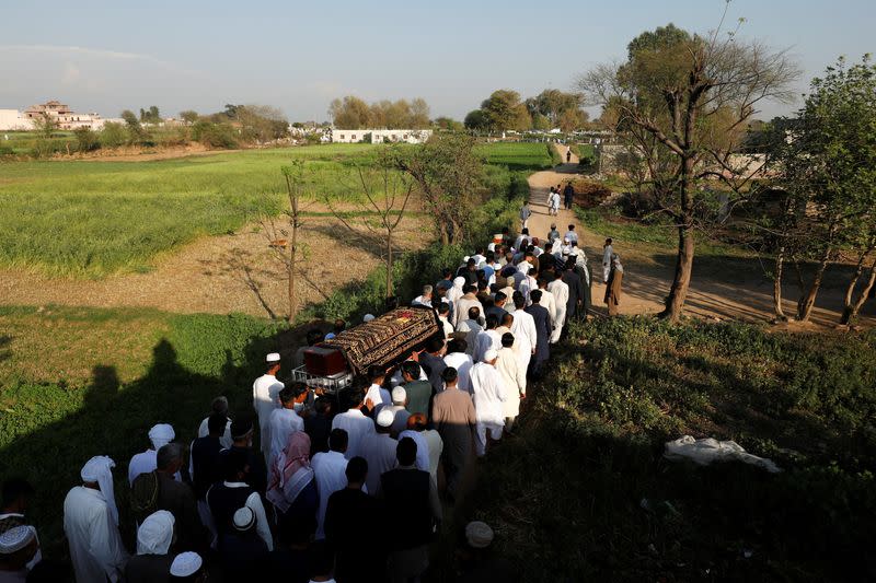 People carry the coffin of Muhammad Ali, 21, during his funeral at a graveyard in Bhojpur town in Gujrat