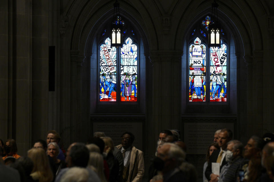 People listen during an unveiling and dedication ceremony at the Washington National Cathedral for the new stained-glass windows with a theme of racial justice, Saturday, Sept. 23, 2023, in Washington. The new windows, titled “Now and Forever," are based on a design by artist Kerry James Marshall. Stained glass artisan Andrew Goldkuhle crafted the windows based on that design. (AP Photo/Nick Wass)