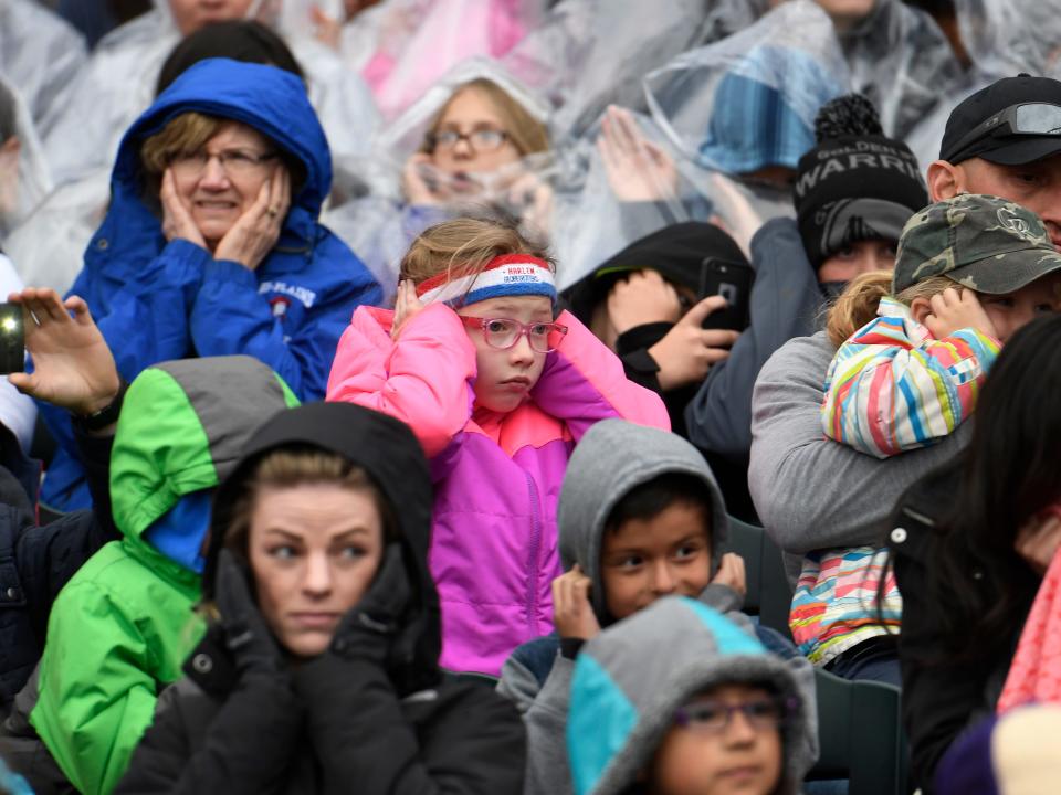 people in a crowd covering their ears