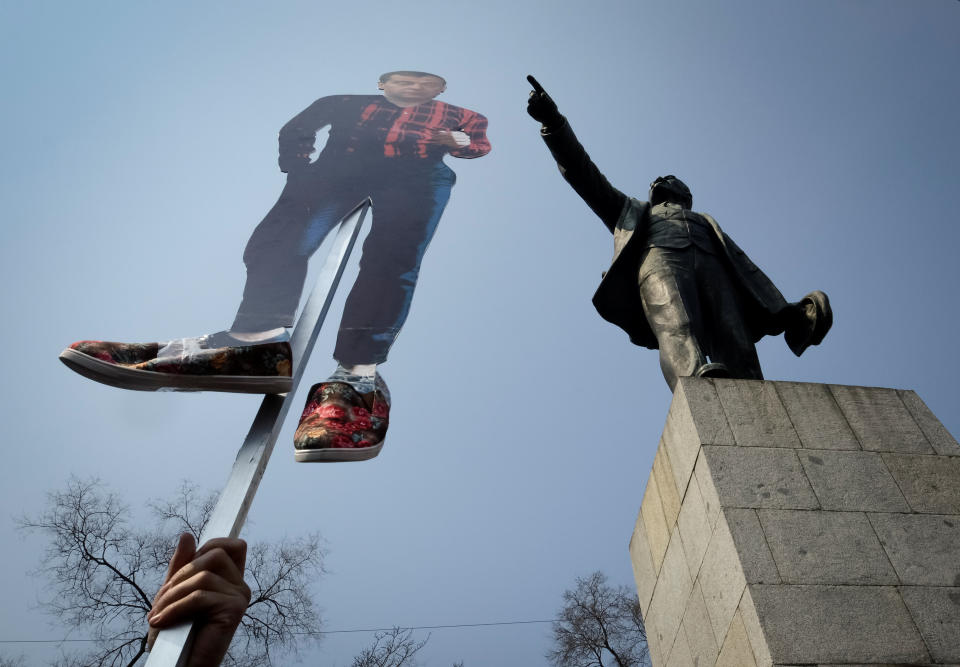 A opposition supporter holds a cutout figure depicting Prime Minister Dmitry Medvedev in Vladivostok.