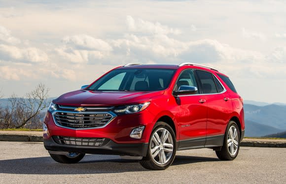 A red 2018 Chevrolet Equinox, a midsize SUV, parked outside with mountains visible in the background.