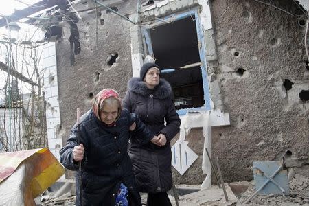 People walk outside a house, which according to locals was recently damaged by shelling, in Donetsk February 3, 2015. REUTERS/Alexander Ermochenko