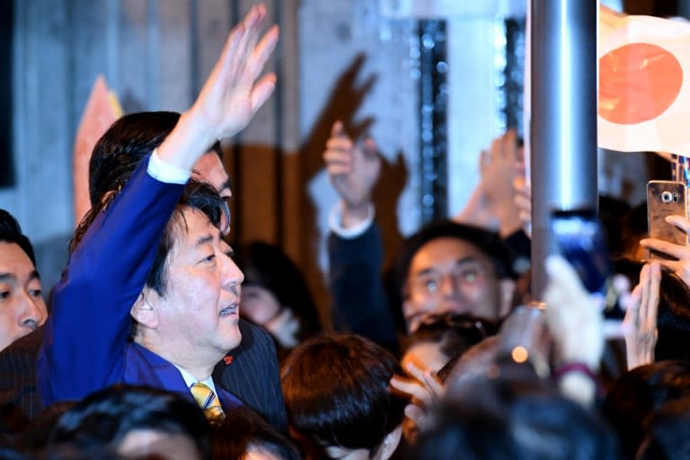 Japan's Prime Minister and ruling Liberal Democratic Party leader Shinzo Abe (L) waves to supporters during his last stumping tour for the October 22 general election in Tokyo on October 21, 2017