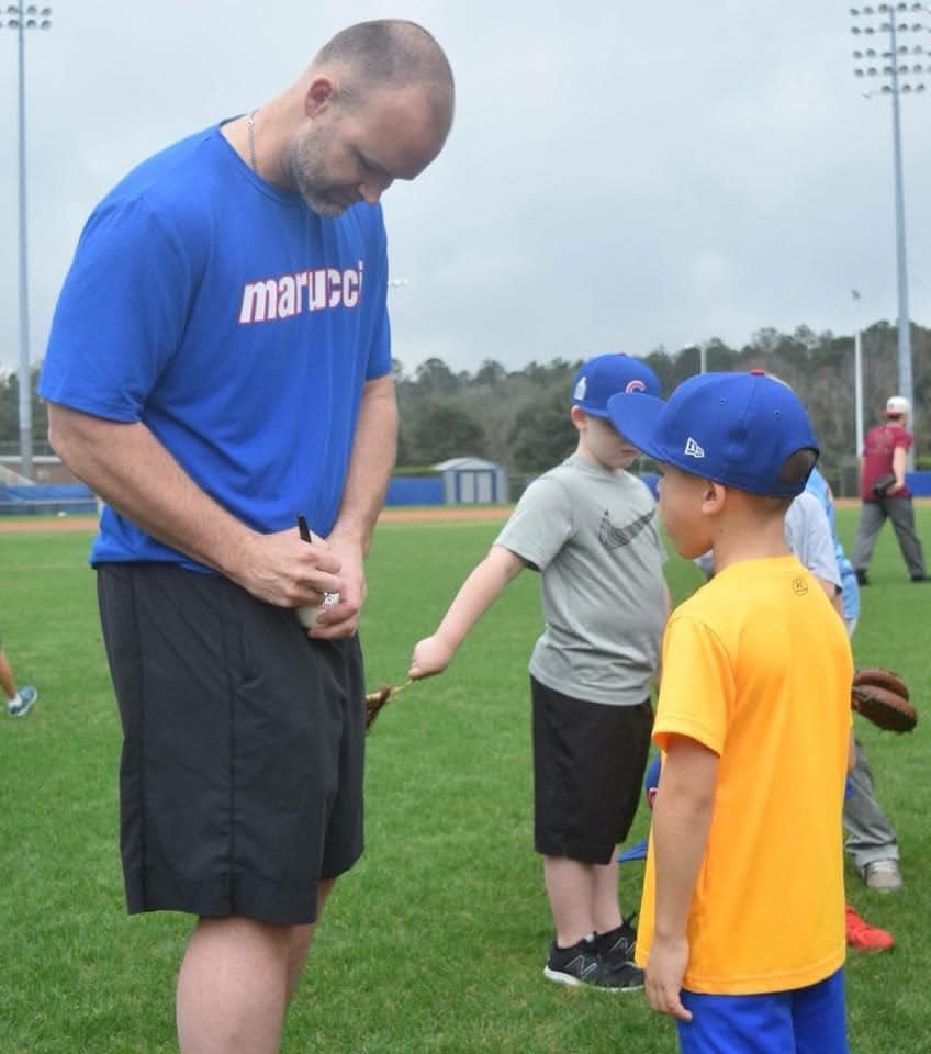 David Ross signs an autograph for a camper at the annual Henry/Ross Father-Son Baseball Camp.