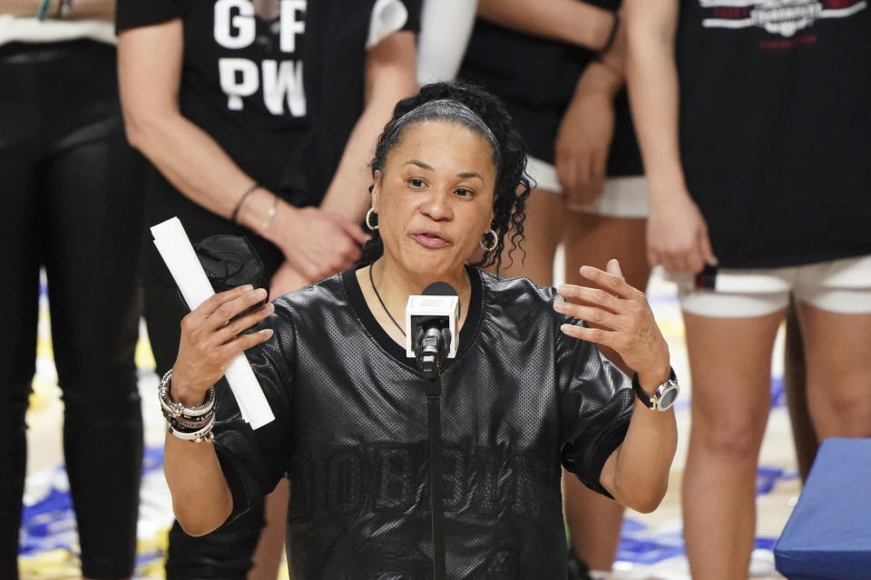 FILE - South Carolina head coach Dawn Staley speaks during a trophy presentation after an NCAA college basketball game against Georgia during the Southeastern Conference tournament final in Greenville, S.C., in this March 7, 2021, file photo. Dawn Staley and South Carolina have agreed to a new, seven-year contract that will pay her $2.9 million this season and grow to $3.5 million in the final season. The school's Board of Trustees approved the deal worth $22.4 million on Friday, Oct. 15, 2021, to keep the national championship coach with the Gamecocks through the 2027-28 season.(AP Photo/Sean Rayford, File)