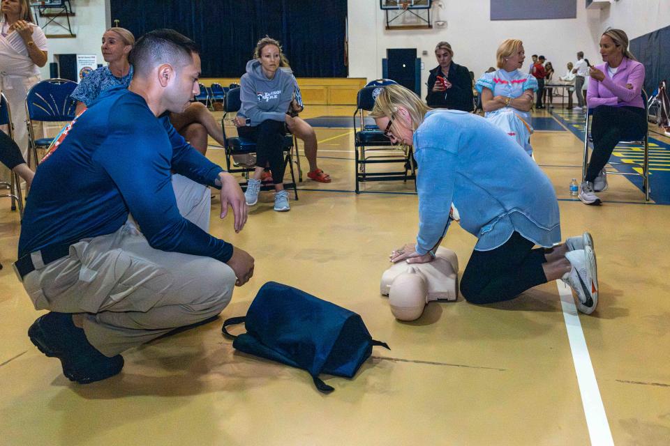 West Palm Beach firefighter Lt. Alejandro Moreno watches as Mae Ferguson practices child CPR during a free parent CPR certification class last week at Palm Beach Day Academy.