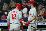 Philadelphia Phillies' Kyle Schwarber (12) is congratulated by Bryce Harper (3) after hitting a home run against the Houston Astros during the eighth inning of a baseball game Monday, Oct. 3, 2022, in Houston. (AP Photo/David J. Phillip)