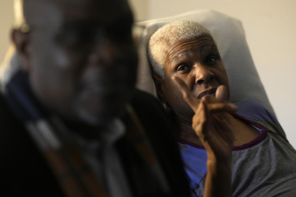 Mary Brooks gestures toward Harvey, Ill., Mayor Christopher J. Clark, left, as Clark talks with reporters Monday, Jan. 8, 2024, in Harvey, during his visit to an apartment complex where a few residents found their homes boarded up and some while they were inside. Brooks, 66, had one of the few apartments that wasn't boarded up. A cancer survivor who has mental health issues, she said she doesn't have anywhere else to go. She said she has tried to reach the city multiple times on other issues over her nearly four years of living at the complex, something she communicated to the mayor. (AP Photo/Charles Rex Arbogast)