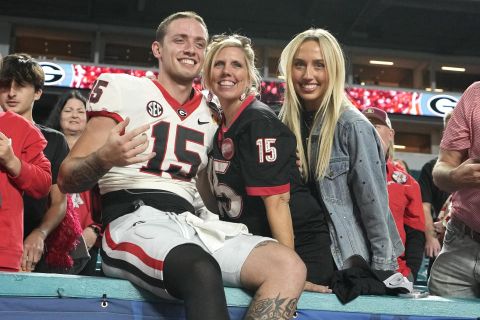 Georgia quarterback Carson Beck (15) sits with his mother Tracy, center, after the Orange Bowl NCAA college football game against Florida State, Saturday, Dec. 30, 2023, in Miami Gardens, Fla. (AP Photo/Lynne Sladky)