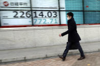 A man walks past an electronic stock board showing Japan's Nikkei 225 index at a securities firm in Tokyo Tuesday, Feb. 25, 2020. Shares are mostly lower in Asia on Tuesday after Wall Street suffered its worst session in two years, with the Dow Jones Industrial Average slumping more than 1,000 points on fears that a viral outbreak that began in China will weaken the world economy.(AP Photo/Eugene Hoshiko)