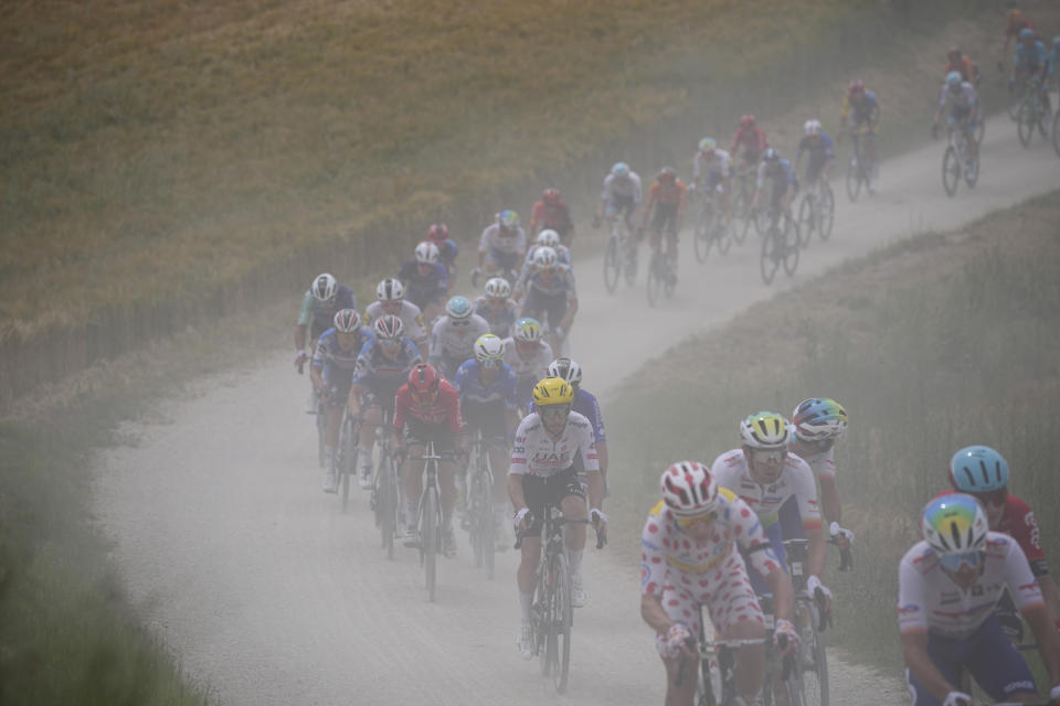 The pack rides on a gravel road during the ninth stage of the Tour de France cycling race over 199 kilometers (123.7 miles) with start and finish in Troyes, France, Sunday, July 7, 2024. (AP Photo/Daniel Cole)