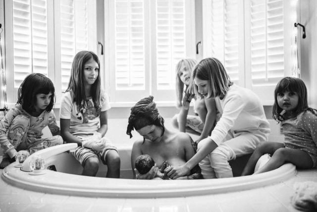 A mother places her baby in a special 'bath bucket' in Sieversdorf,  Germany, 18 July 2010. The bath bucket's from makes the baby assume a  posture similar to the one it had