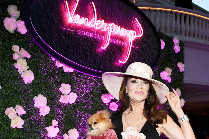 Lisa Vanderpump in front of a Vanderpump Cocktail Garden sign.