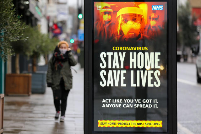 LONDON, UNITED KINGDOM - 2021/01/12: A woman walks past the Government&#39;s &#39;Stay Home, Save Lives&#39; Covid-19 publicity campaign poster in London, as the number of cases of the mutated variant of the SARS-Cov-2 virus continues to spread around the country. (Photo by Dinendra Haria/SOPA Images/LightRocket via Getty Images)