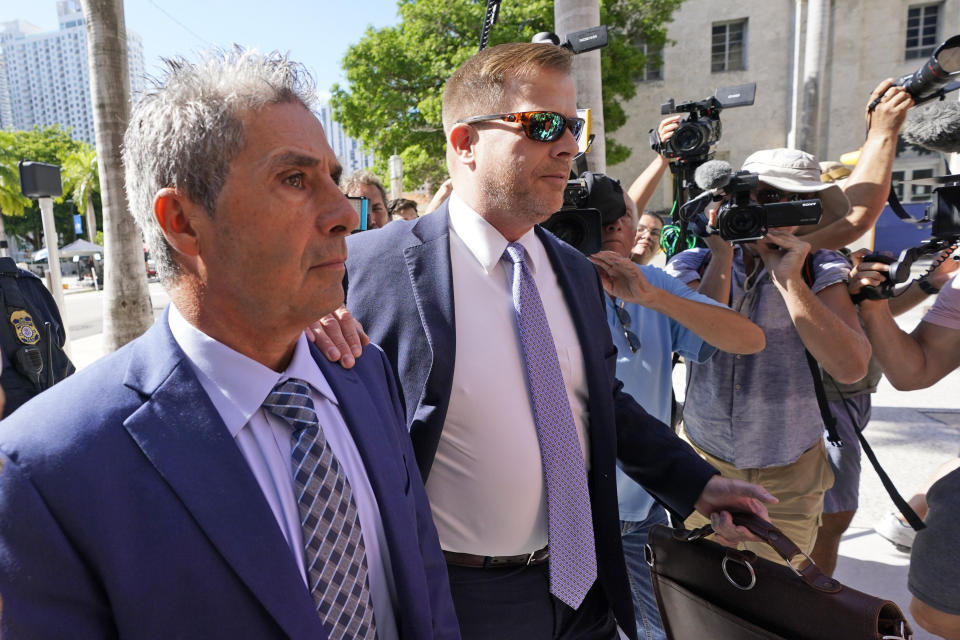 Carlos De Oliveira, left, an employee of Donald Trump's Mar-a-Lago estate, arrives for a court appearance with attorney John Irving, at the James Lawrence King Federal Justice Building, Monday, July 31, 2023, in Miami. De Oliveira, Mar-a-Lago's property manager, was added last week to the indictment with Trump and the former president's valet, Walt Nauta, in the federal case alleging a plot to illegally keep top-secret records at Trump's Florida estate and thwart government efforts to retrieve them. (AP Photo/Wilfredo Lee)