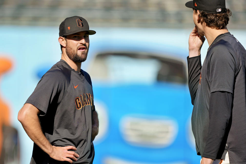 San Francisco Giants pitcher Tristan Beck, left, talks with teammate Sean Hjelle during warm ups before making his big-league baseball debut in a game against the New York Mets on Thursday, April 20, 2023, in San Francisco. Tiffany Fuentes and her family hosted San Jose Giants players from 2012 to 2019, including six future big leaguers — catchers Joey Bart and Trevor Brown, outfielder Adam Duvall, and pitchers Sam Coonrod, Trevor Brown and Tristan Beck. The Fuentes family was present when Beck made his big-league debut. (AP Photo/Tony Avelar)