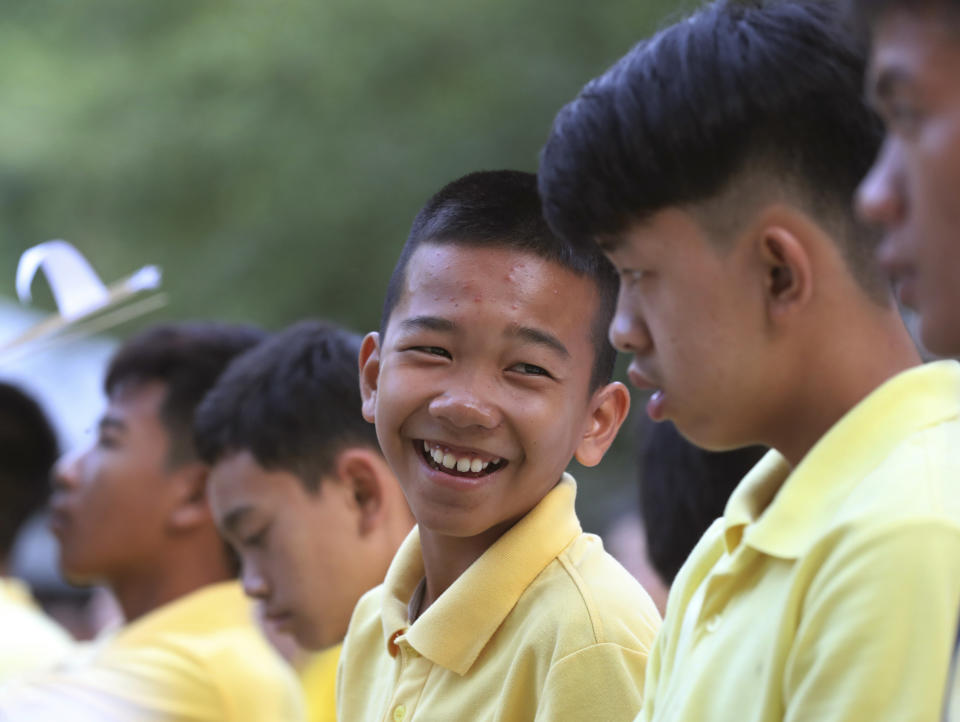 Chanin Vibulrungruang, center, talks to Pornchai Kamluang, right, both are members of the Wild Boars soccer team who were rescued from a flooded cave, before a religious ceremony at Tham Luang in Mae Sai, Chiang Rai province, Thailand Monday, June 24, 2019. The 12 boys and their coach attended a Buddhist merit-making ceremony at the Tham Luang to commemorate the one-year anniversary of their ordeal that saw them trapped in a flooded cave for more than two weeks. (AP Photo/Sakchai Lalit)