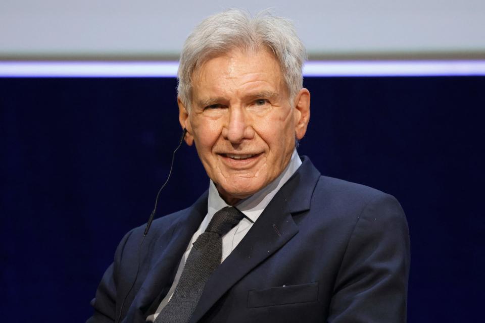 Ford in a suit and tie speaking at an event