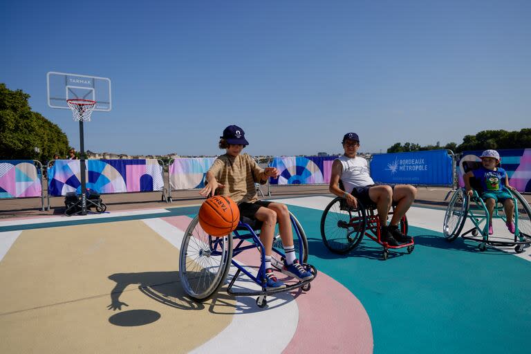 Chicos jugando al básquetbol en un espacio especial organizado por París 2024, junto al río Garona, que atraviesa Burdeos