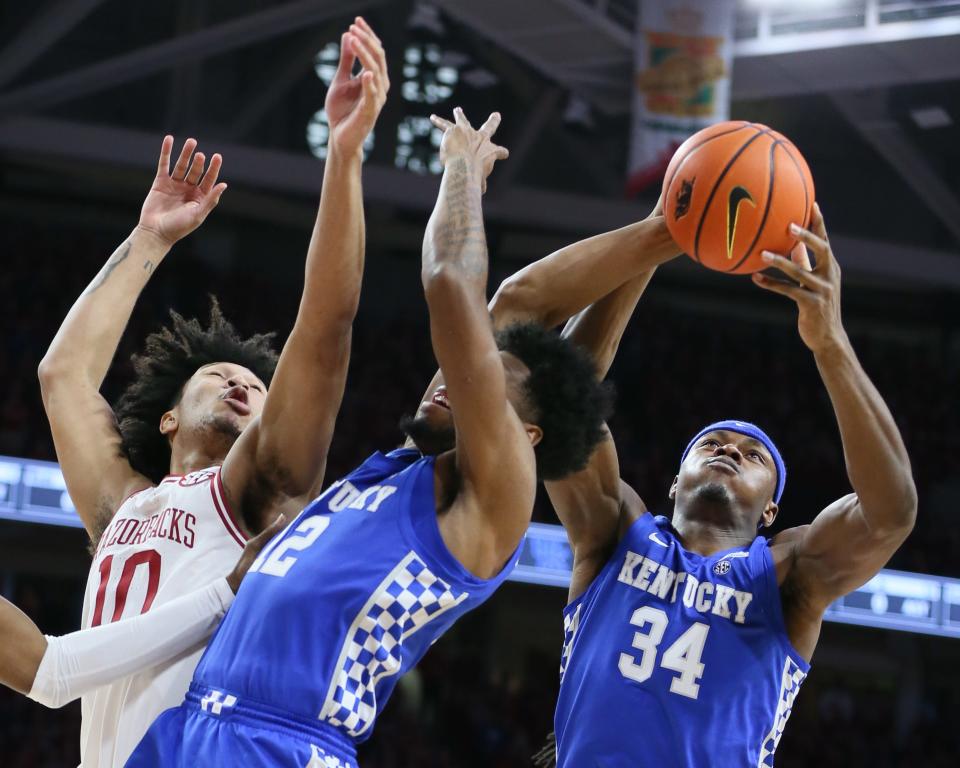 Kentucky Wildcats forward Oscar Tshiebwe (34) grabs a rebound from forward Keion Brooks Jr. (12) and Arkansas Razorbacks forward Jaylin Williams (10) in the first half at Bud Walton Arena.