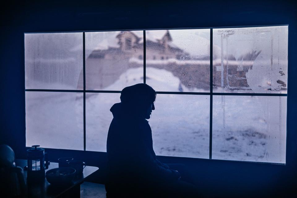 The silhouette of a person sitting in a tent.