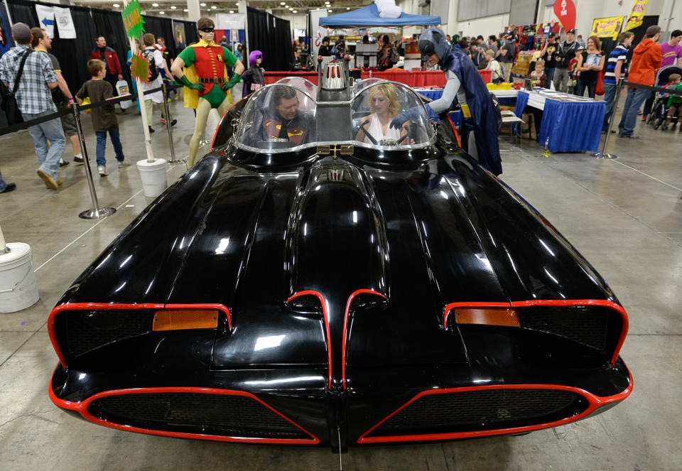 Fans get a chance to sit in the 1966 Batmobile for a picture at the Salt Palace Convention Center in Salt Lake City, Utah, Friday April 18, 2014, for day two of Salt Lake Comic Con's FanX. (AP Photo/The Salt Lake Tribune, Francisco Kjolseth)