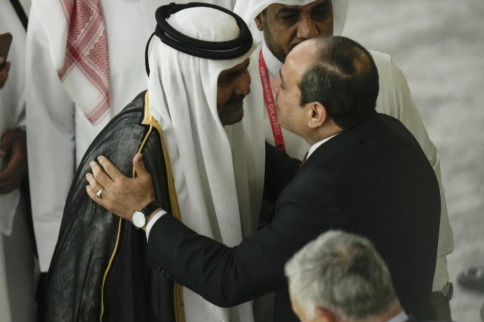 Former Emir of Qatar Sheikh Hamad bin Khalifa Al Thani, centre left, and Egyptian President Abdel Fattah el-Sisi, right, greet each other before the start of the World Cup, group A soccer match between Qatar and Ecuador at the Al Bayt Stadium in Al Khor, Qatar, Sunday, Nov. 20, 2022. (AP Photo/Hassan Ammar)