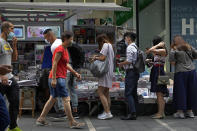 People queue up to buy Apple Daily at a downtown street in Hong Kong Friday, June 18, 2021. The pro-democracy paper increased its print run to 500,000 copies on Friday, a day after police arrested five top editors and executives and froze $2.3 million in assets linked to the media company. (AP Photo/Vincent Yu)