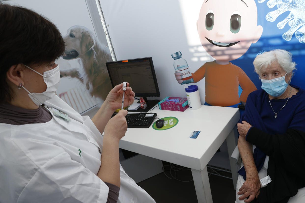 A healthcare worker prepares to administer a COVID-19 vaccine to an Israeli woman at Clalit Health Services, in the coastal city of Tel Aviv, on January 3, 2021. - Israel said two million people will have received a two-dose COVID-19 vaccination by the end of January, since the start on December 19, of an aggressive push to administer the vaccine made by US-German pharma alliance Pfizer-BioNTech. (Photo by JACK GUEZ / AFP) (Photo by JACK GUEZ/AFP via Getty Images)