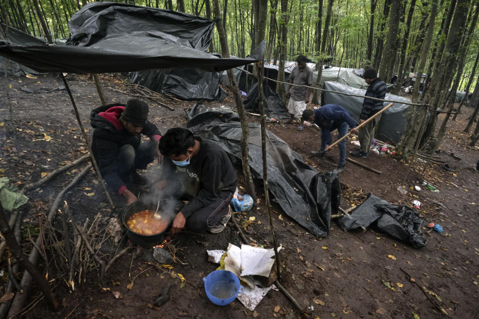 Migrants cook at a makeshift camp outside Velika Kladusa, Bosnia, Saturday, Sept. 26, 2020. Remote woods, abandoned run-down buildings and roadsides on the fringes of northwestern Bosnian towns are steadily filling with makeshift camps where migrants from the Middle East, Asia and North Africa are bracing for more misery as autumn's chill and rains set it. (AP Photo/Kemal Softic)