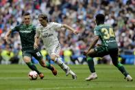 Real Madrid's Luka Modric, center, duels for the ball against Betis player Lo Celso, left and Betis player Kaptoum during a Spanish La Liga soccer match at the Santiago Bernabeu stadium in Madrid, Spain, Sunday, May 19, 2019. (AP Photo/Bernat Armangue)