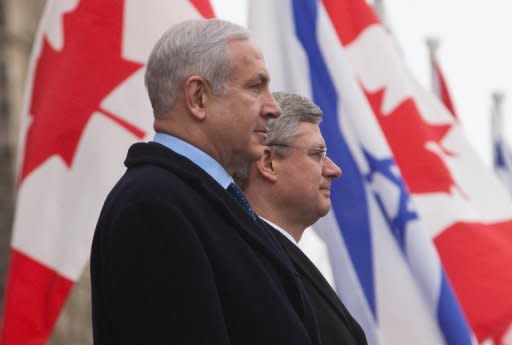 Canadian Prime Minister Stephen Harper (R) and Israeli counterpart Benjamin Netanyahu pause for national anthems on Parliament Hill in Ottawa. Netanyahu says all options remain on the table concerning action on Iran