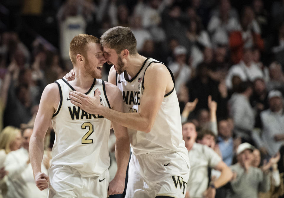 Wake Forest guard Cameron Hildreth (2) and forward Andrew Carr (11) celebrate in overtime of an NCAA college basketball game against Miami, Saturday, Jan. 6, 2024, in Winston-Salem, N.C. (Allison Lee Isley/The Winston-Salem Journal via AP)