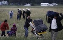 A refugee family carry their belongings during a police operation at a refugee camp at the border between Greece and Macedonia, near the village of Idomeni, Greece, 24 May 2016. REUTERS/Yannis Kolesidis/Pool