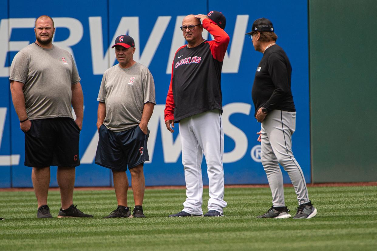 Unidentified members of the Cleveland Guardians grounds crew wait with Guardians manager Terry Francona, second from right, and Chicago White Sox manager Tony LaRussa, right, for umpires as they inspect the condition of Progressive Field before a baseball game in Cleveland, Sunday, Aug. 21, 2022. (AP Photo/Phil Long)