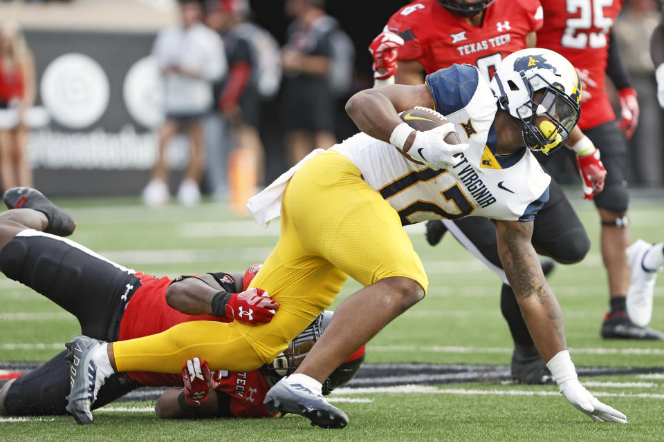 West Virginia's CJ Donaldson Jr. (12) tries to break away from Texas Tech's Marquis Waters (9) during the second half of an NCAA college football game Saturday, Oct. 22, 2022, in Lubbock, Texas. (AP Photo/Brad Tollefson)