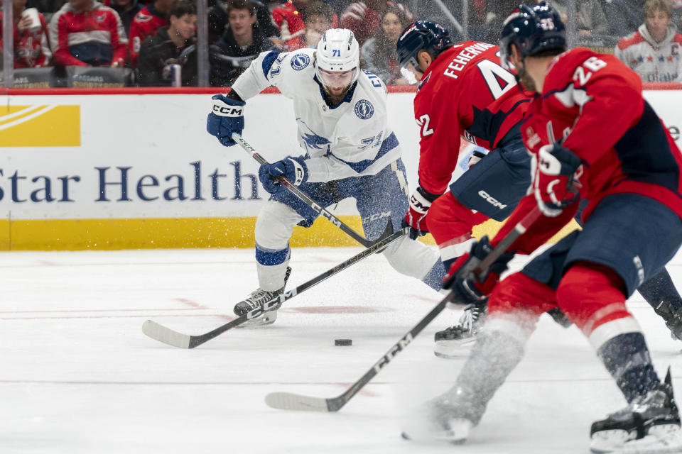 Tampa Bay Lightning center Anthony Cirelli (71) advances toward the net as Washington Capitals defenseman Martin Fehervary (42) and Capitals right wing Nic Dowd (26) defend during the second period of an NHL hockey game, Saturday, Dec. 23, 2023, in Washington. (AP Photo/Stephanie Scarbrough)