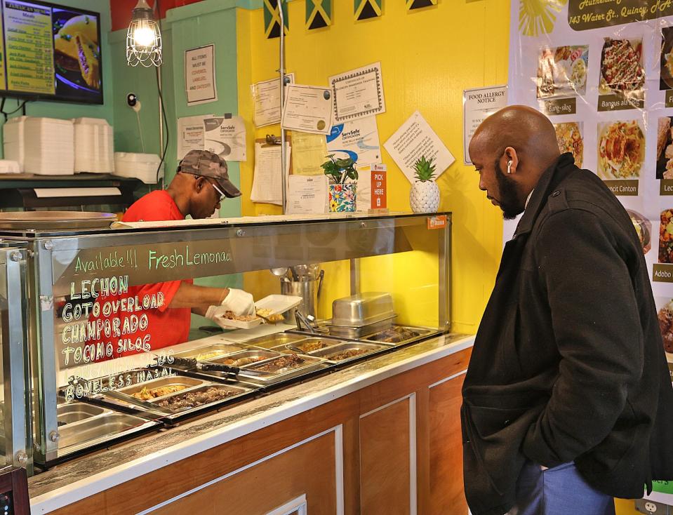 Antoine Jamison, of Quincy, a regular customer at Bright Light Authentic Jamaican & Filipino Cuisine on Water Street in Quincy, waits for his curried chicken and rice plate on Tuesday, March 5, 2024.