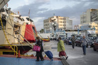 Passenger wearing masks to curb the spread of the coronavirus board a ferry at the Piraeus port near Athens on Monday, May 25, 2020. Greece restarted Monday regular ferry services to the islands as the country accelerated efforts to salvage its tourism season. (AP Photo/Petros Giannakouris)