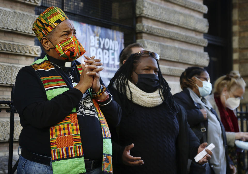 The Rev. Chris Long, assistant senior minister for the Community Church of New York, left, and TJ Williams, second from left, pray with a group of interfaith leaders gathered outside of the Judson Memorial Church near Washington Square Park in New York, Wednesday, Nov. 4, 2020. Muslims, Jews, Christians and Buddhists came together to show solidarity among faith communities as the country awaits the final result of the U.S. presidential election. (AP Photo/Jessie Wardarski)