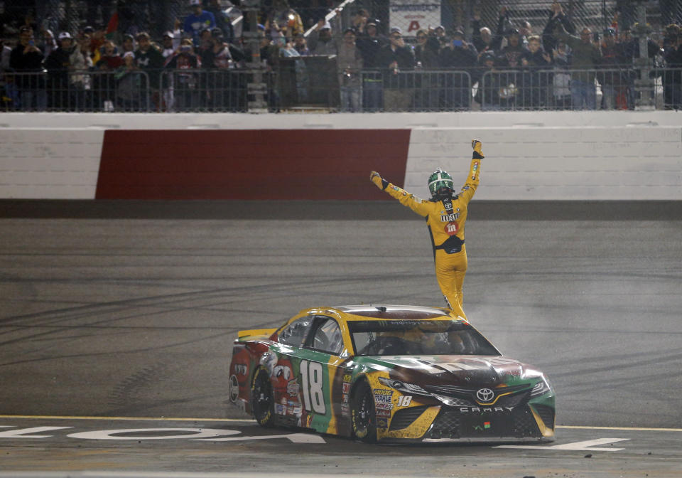 Kyle Busch waves to the fans as he celebrates winning the NASCAR Cup Series auto race at Richmond Raceway in Richmond, Va., Saturday, April 21, 2018. (AP Photo/Steve Helber)