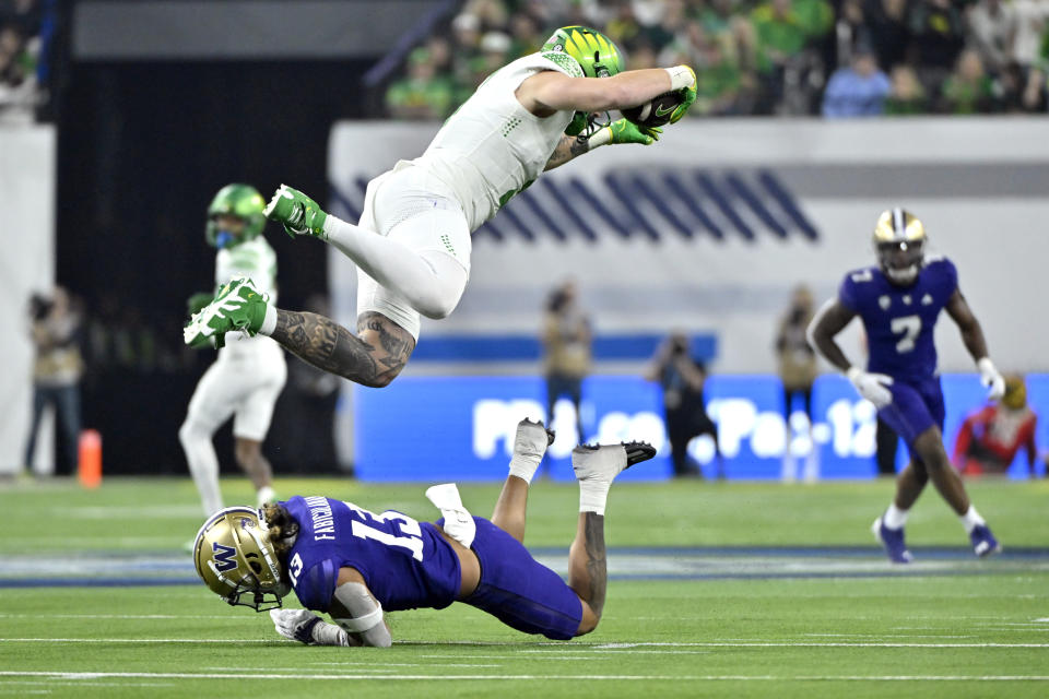 Oregon tight end Terrance Ferguson (3) is tripped by Washington cornerback Kamren Fabiculanan (13) during the first half of the Pac-12 championship NCAA college football game Friday, Dec. 1, 2023, in Las Vegas. (AP Photo/David Becker)