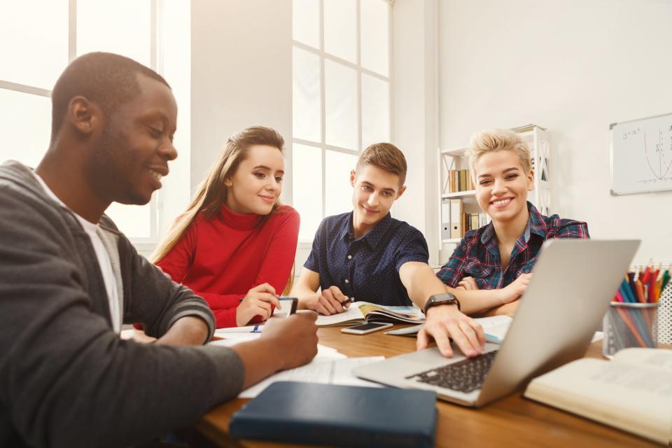 Group of teens around a laptop