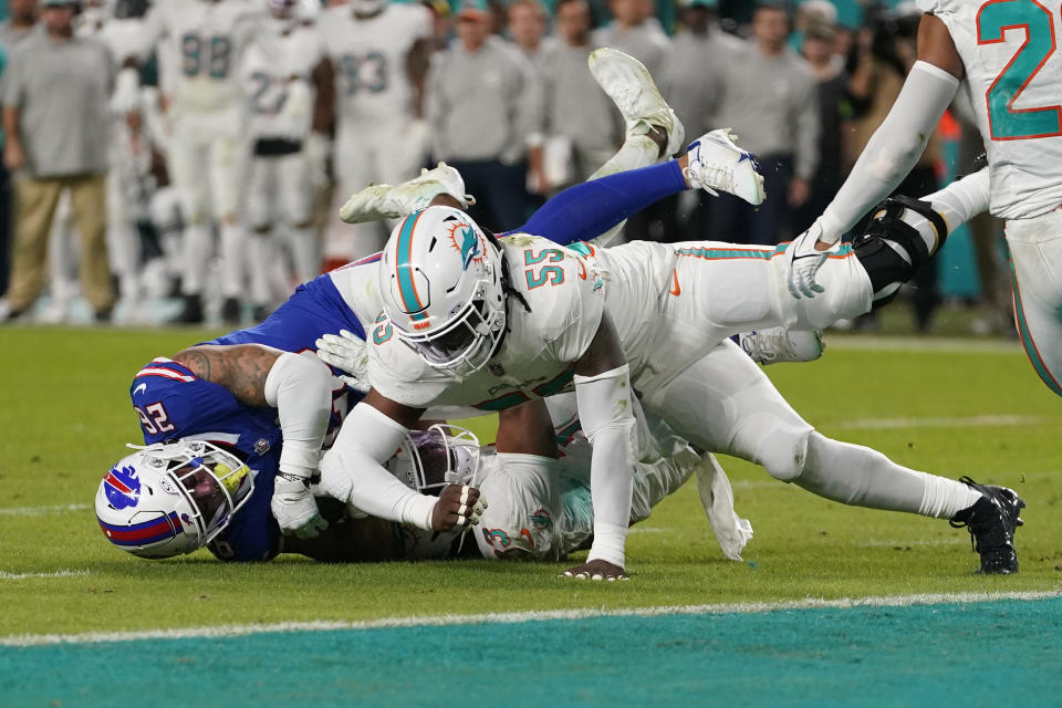 Miami Dolphins linebacker Jerome Baker (55) and cornerback Eli Apple (33) stop Buffalo Bills running back Ty Johnson (26) during the first half of an NFL football game, Sunday, Jan. 7, 2024, in Miami Gardens, Fla. (AP Photo/Lynne Sladky)